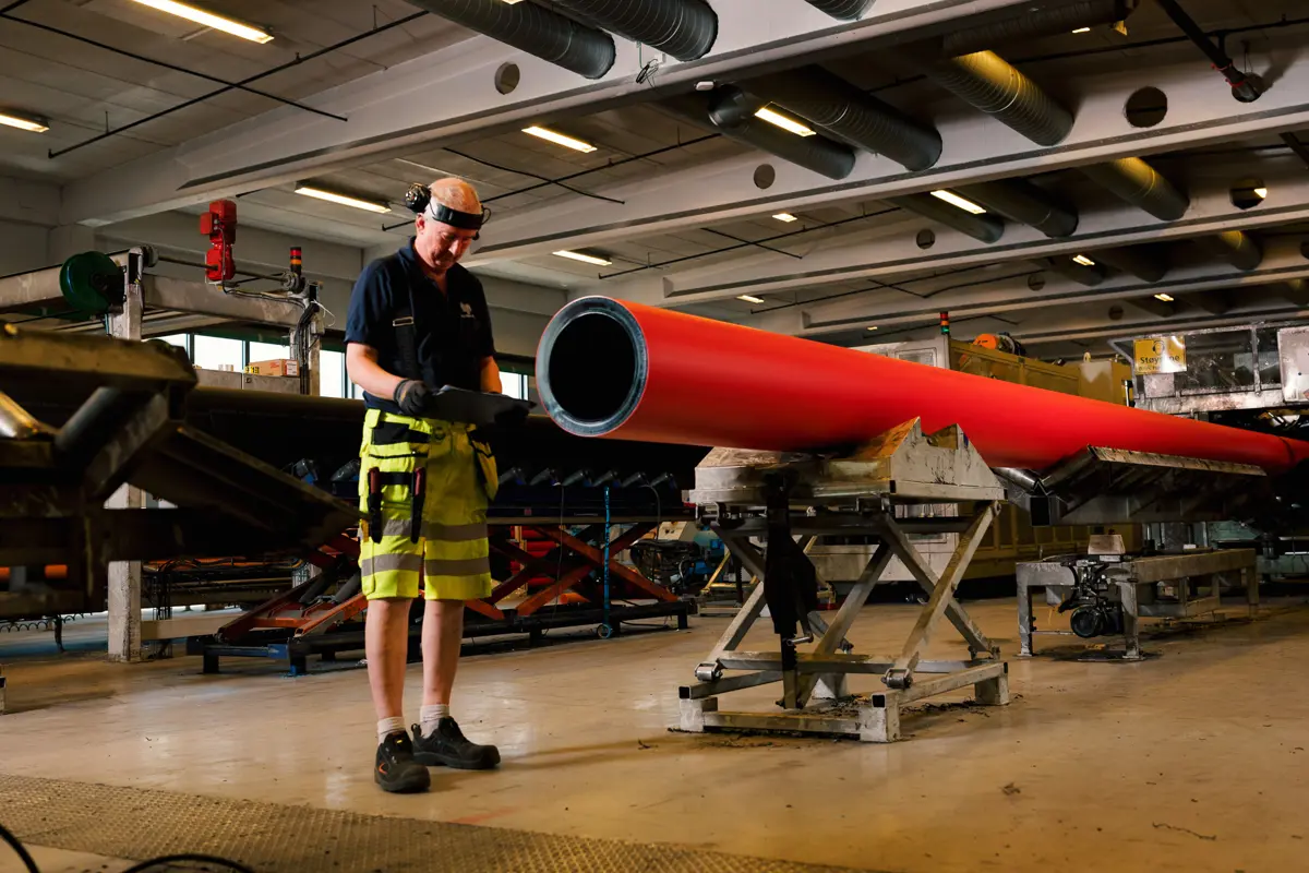 Person måler veggtykkelsen på rør